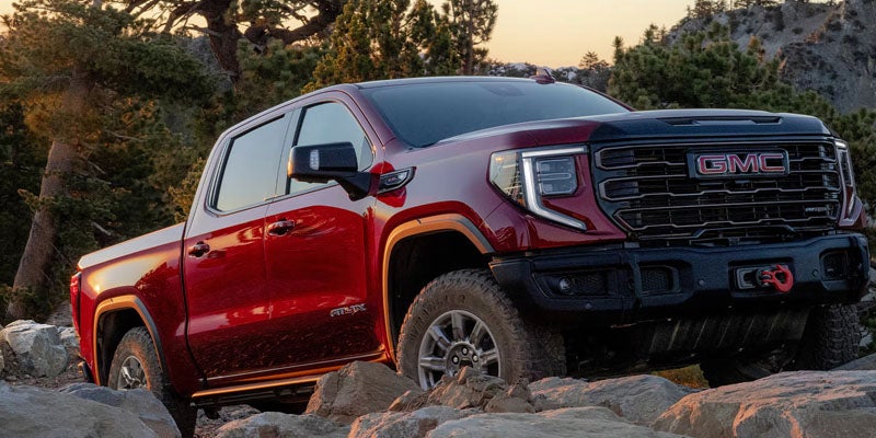 2026 GMC Sierra 1500 AT4 traversing rocks with all-terrain tires and advanced safety systems